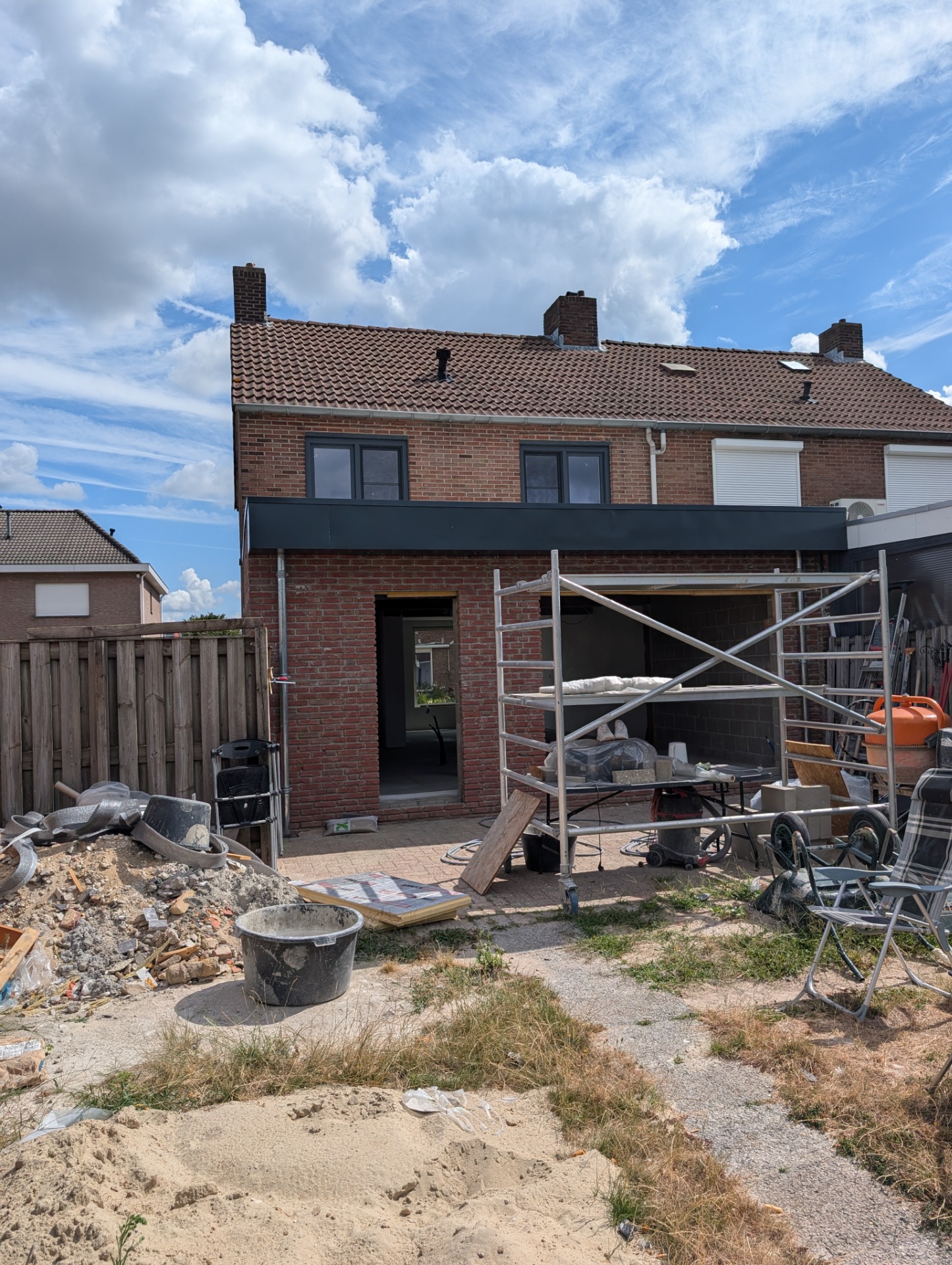 Zwart-wit silhouet van een man op betonnen constructie met hoge stalen staven en omheining.